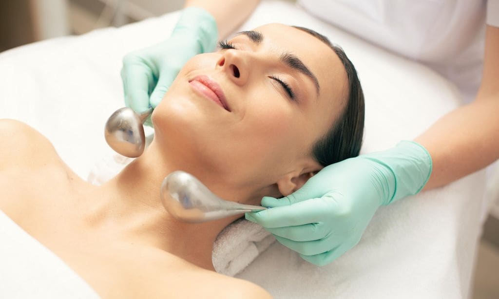 Mujer joven relajada mientras recibe tratamiento con palitos de cryo-sticks.