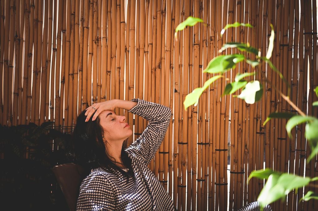 mujer con dolor de cabeza en una terraza