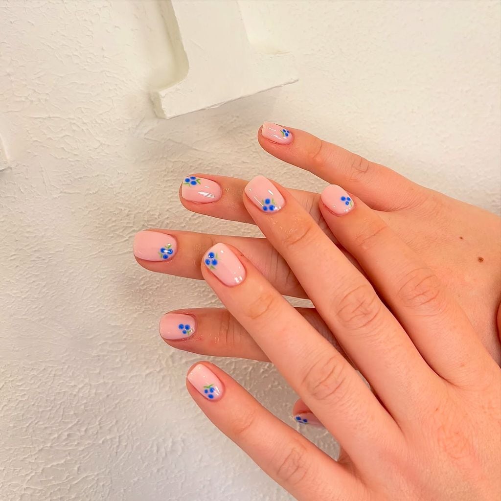 Manicura de uñas cortas con diseño de flores azules