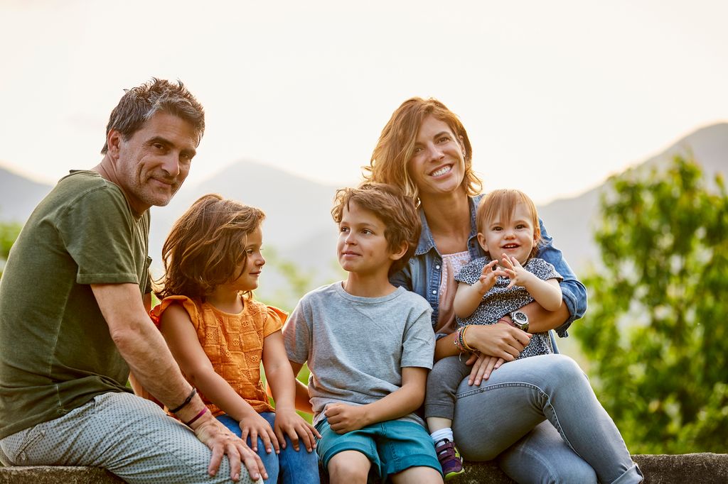 Familia joven con tres hijos al aire libre