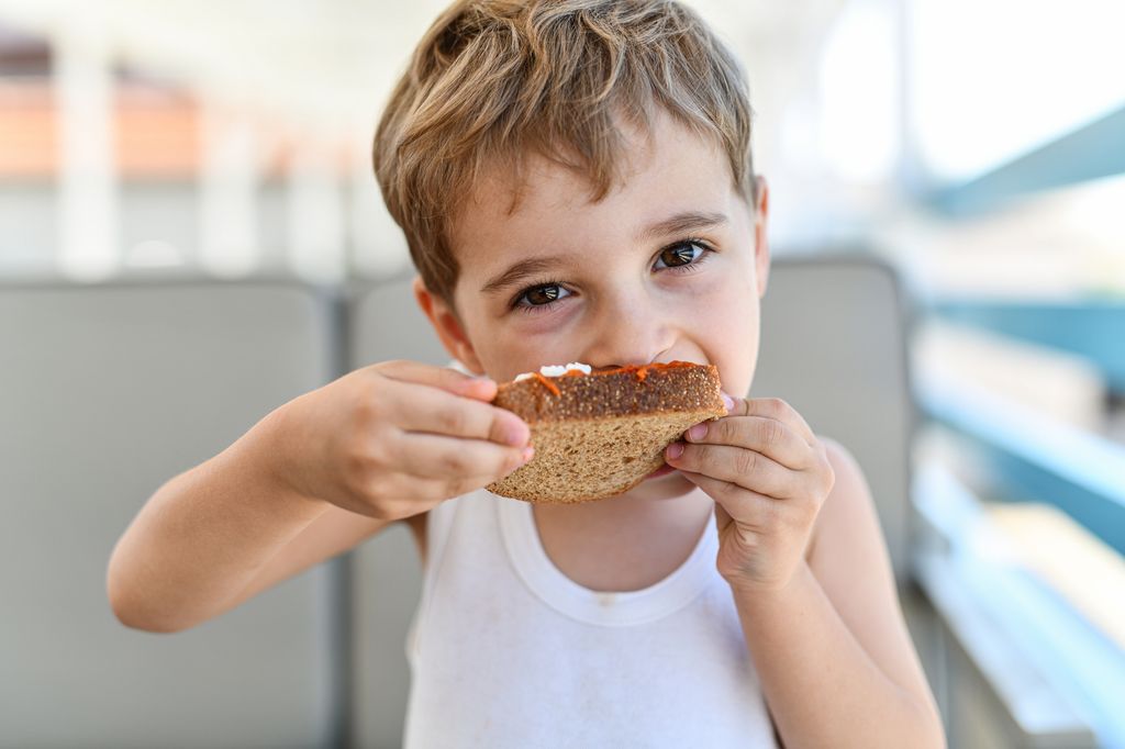 Niño tomando una tostada integral