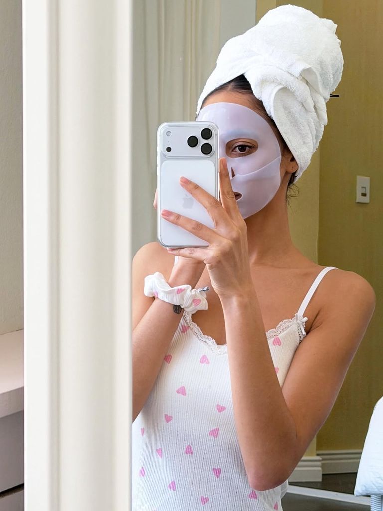 Mujer con mascarilla facial overnight y toalla en el cabello durante su skincare de noche