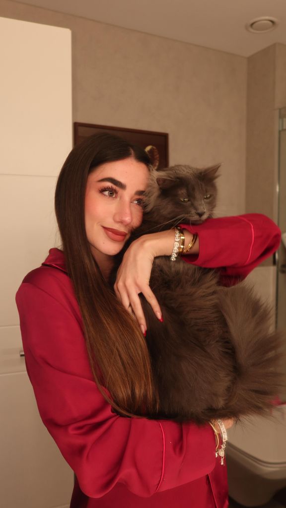 La influencer posa con una de sus mascotas en el baño integrado en su habitación