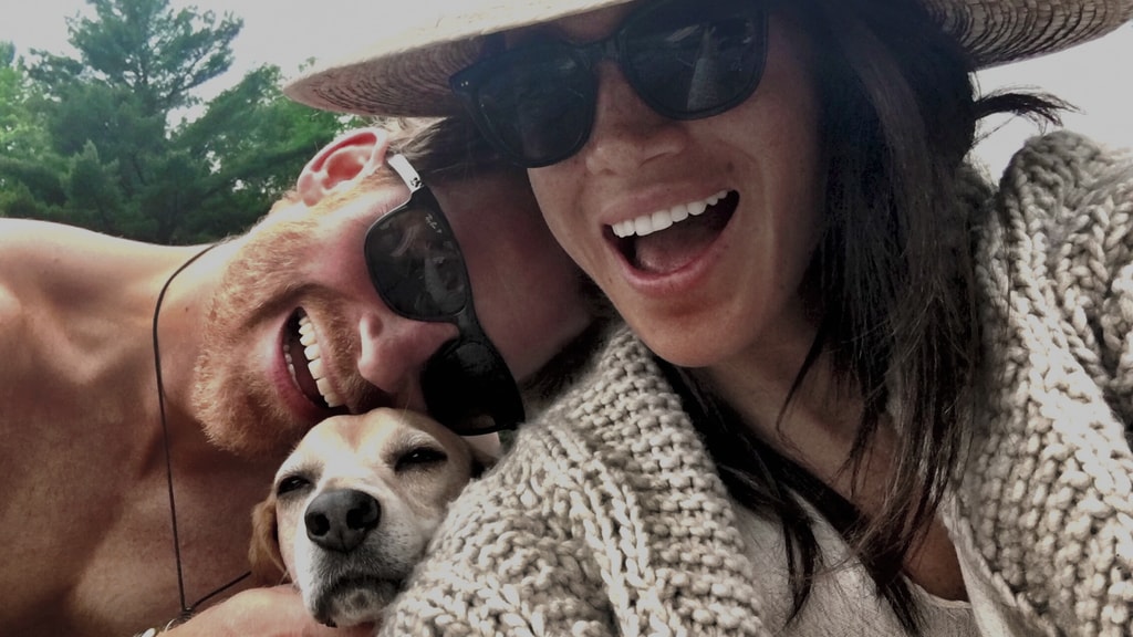 Primer plano de Harry y Meghan posando con su perro y gafas de sol