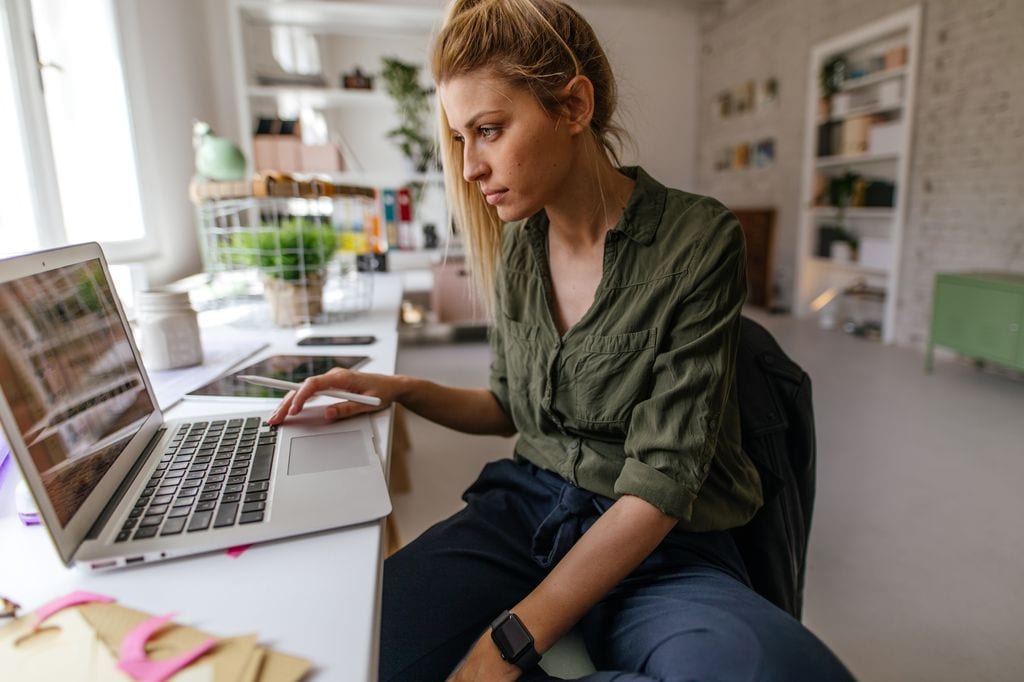 Mujer escribiendo en un ordenador para vender su móvil