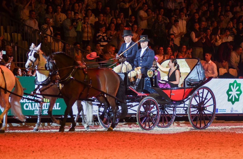 Plano general de Carolina Marín en un carruaje con caballos saludando al público