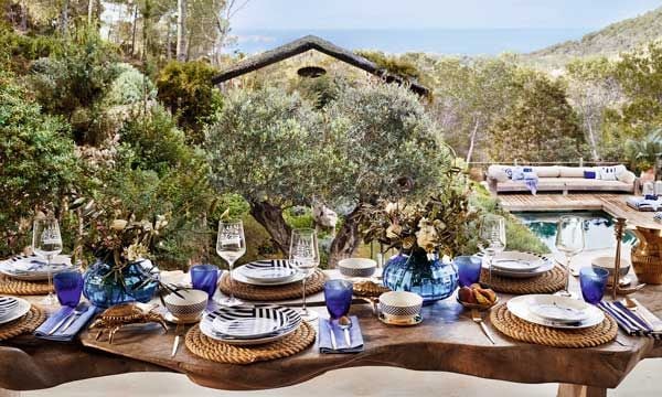 En una mesa perfecta, todo tiene importancia. En este ambiente de Zara Home, los bajoplatos de cuerda, el jarrón con flores naturales, la cristalería de color azul o los guiños decorativos al mar proporcionan un marco idílico.
