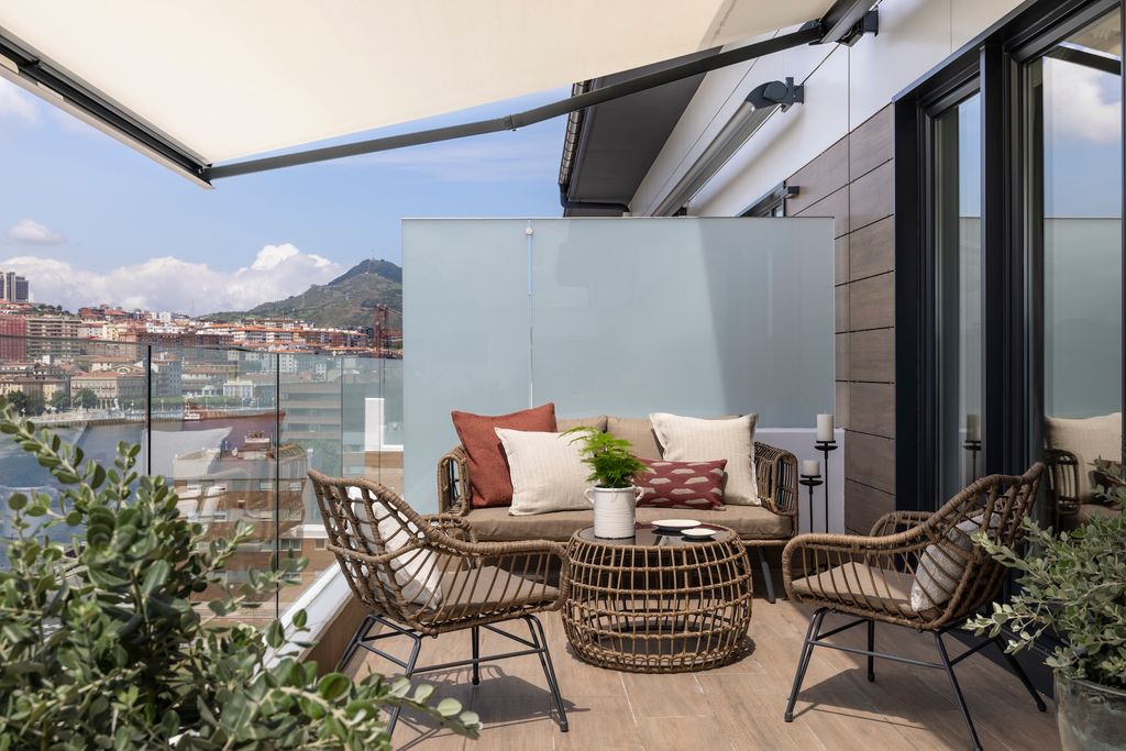 Terraza pequeña con barandilla de cristal.