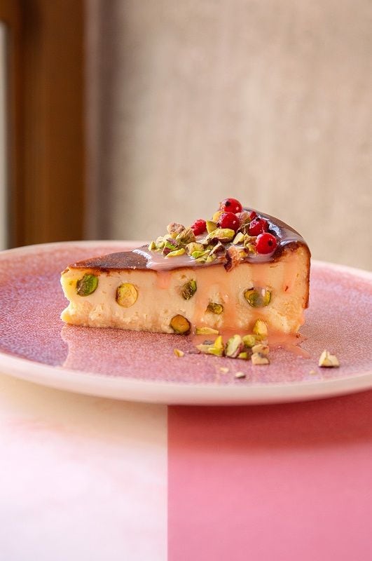 Tarta de queso con pistachos, pink chocolate blanco y frutos rojos