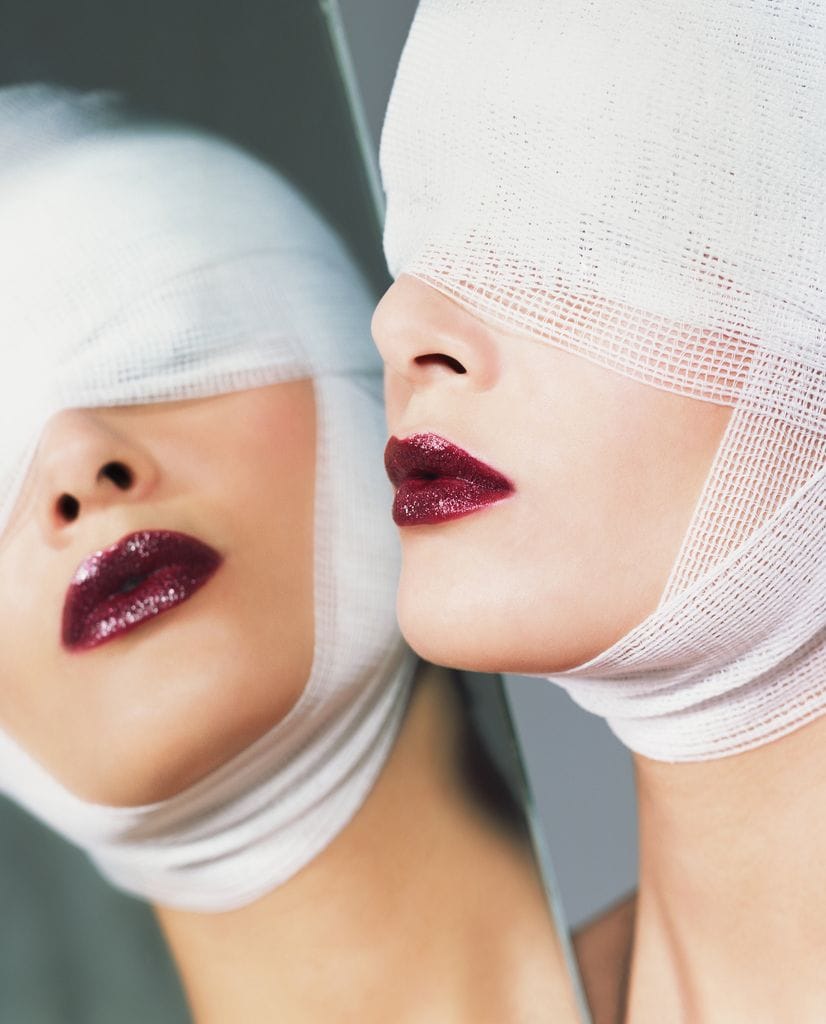 Mujer con vendaje en la cabeza y labios maquillados de granate