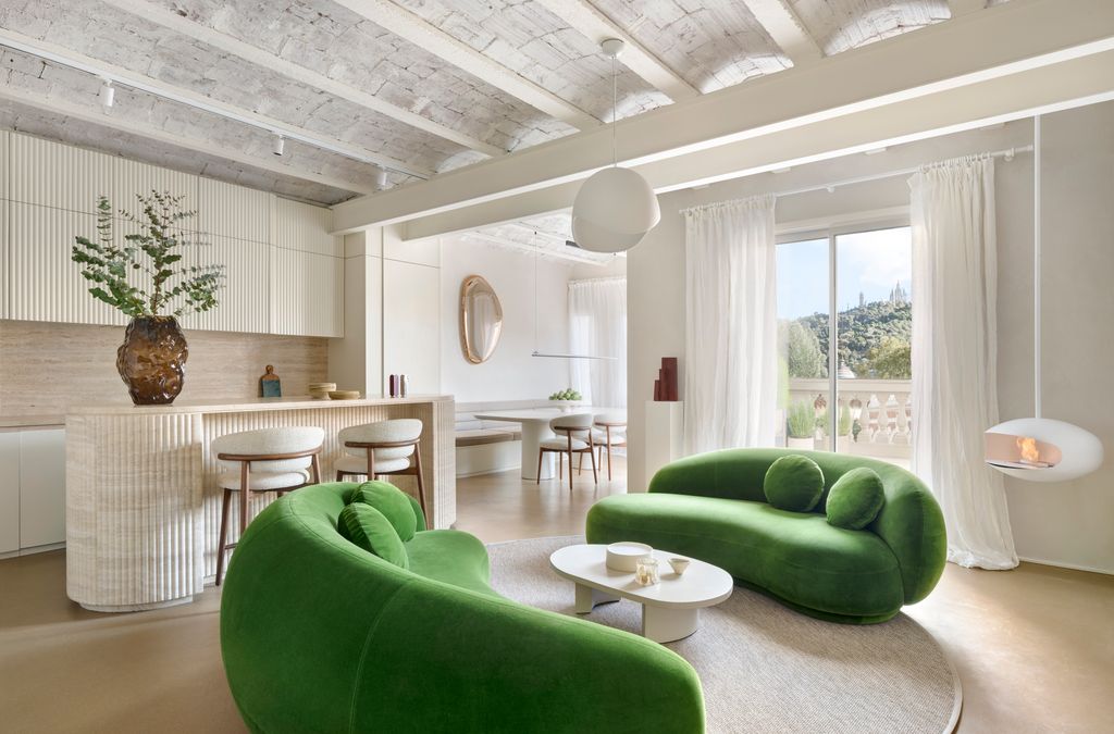 Cocina abierta a un salón con sofás verdes