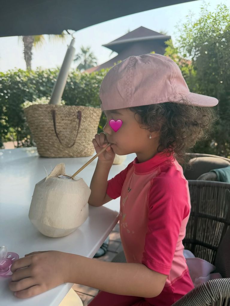 Bella Esmeralda, la más pequeña de la familia, disfrutando de un agua de coco natural.