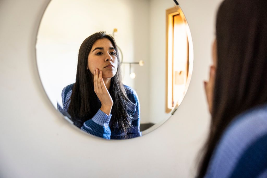 adolescente mirándose en el espejo