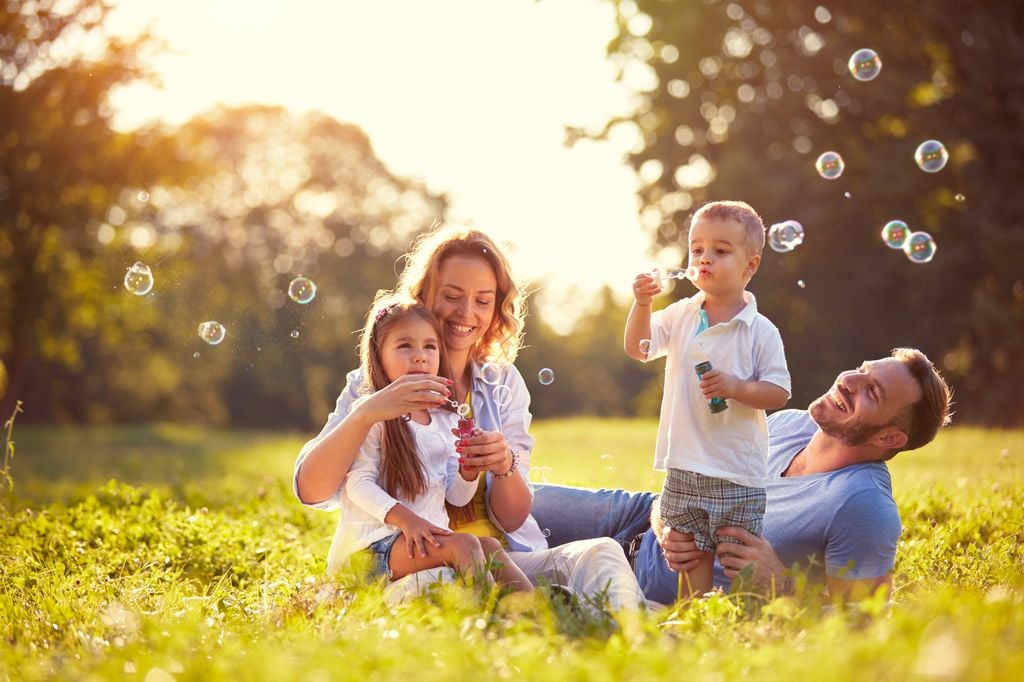 Familia haciendo pompas de jabón en el campo