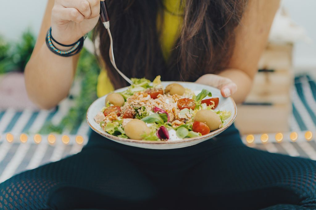 Adolescente tomando un plato vegetariano