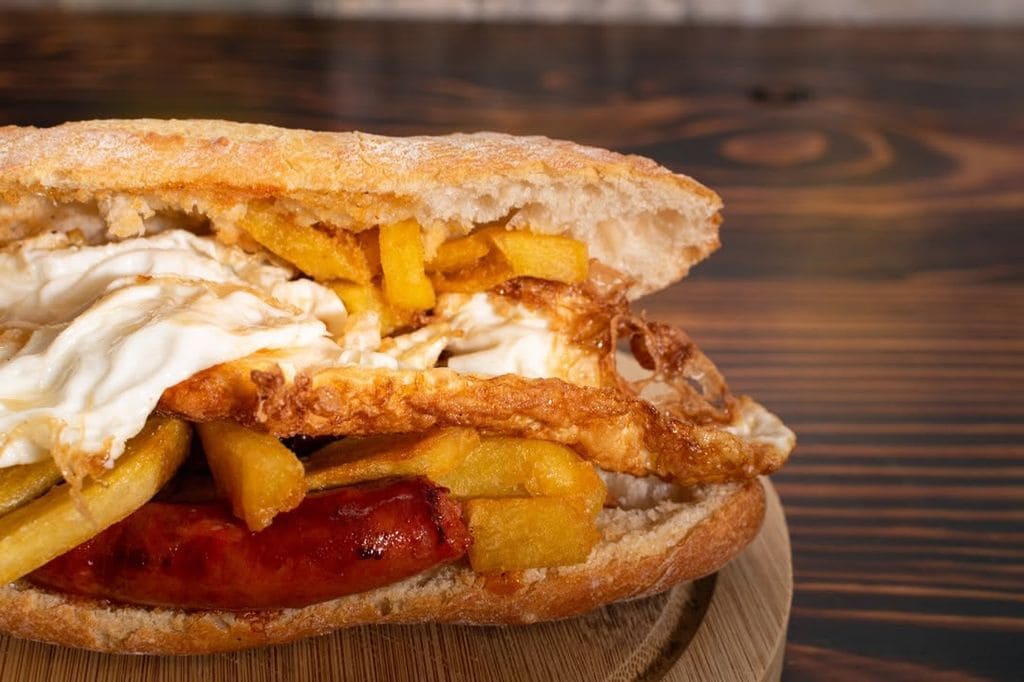 Los huevos con patatas también se pueden tomar en bocata, y con chistorra, como el de BarreXat Bar, en Valencia.
