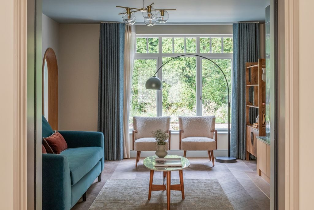 Salón con sofá verde y dos butacas blancas