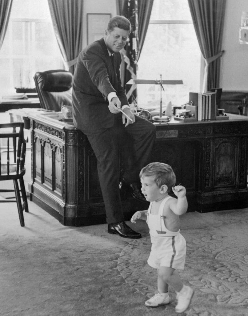 El presidente Kennedy mira a su hijo John de 18 meses desde su despacho de la Casa Blanca
