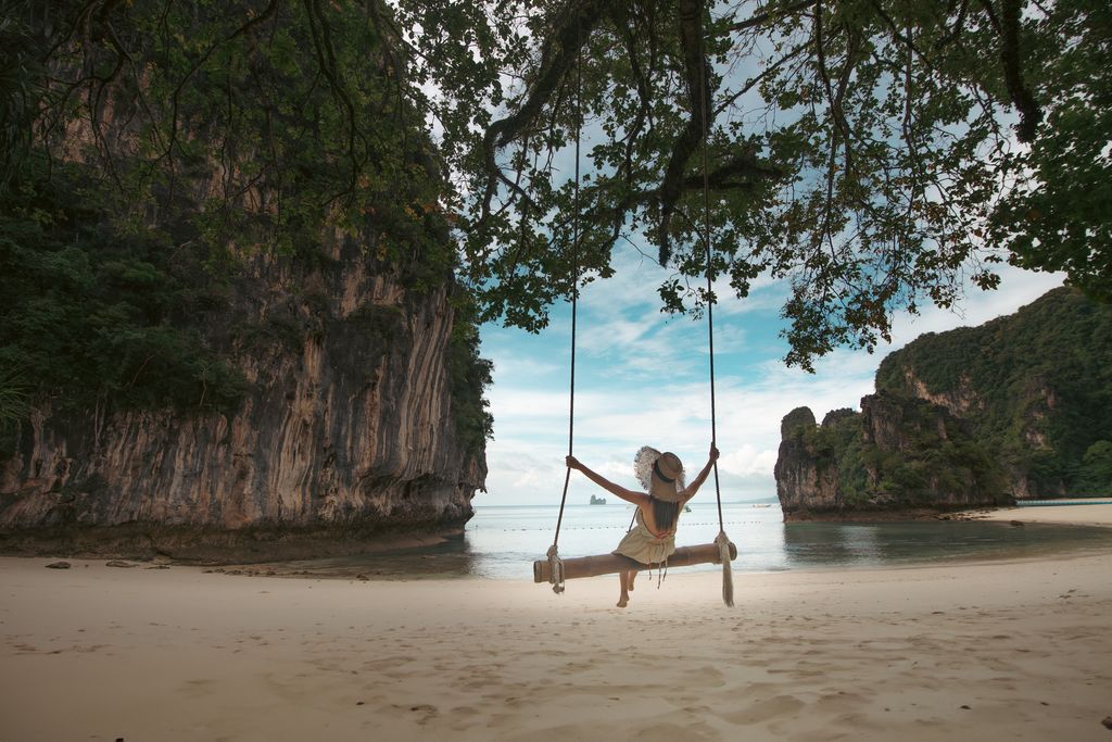 Turista sentada en un columpio de madera disfrutando de un momento de felicidad bajo la sombra de los árboles, en la isla Koh Hong, mar de Andamán, en la isla Phi Phi, en la provincia de Krabi, en el sur de Tailandia