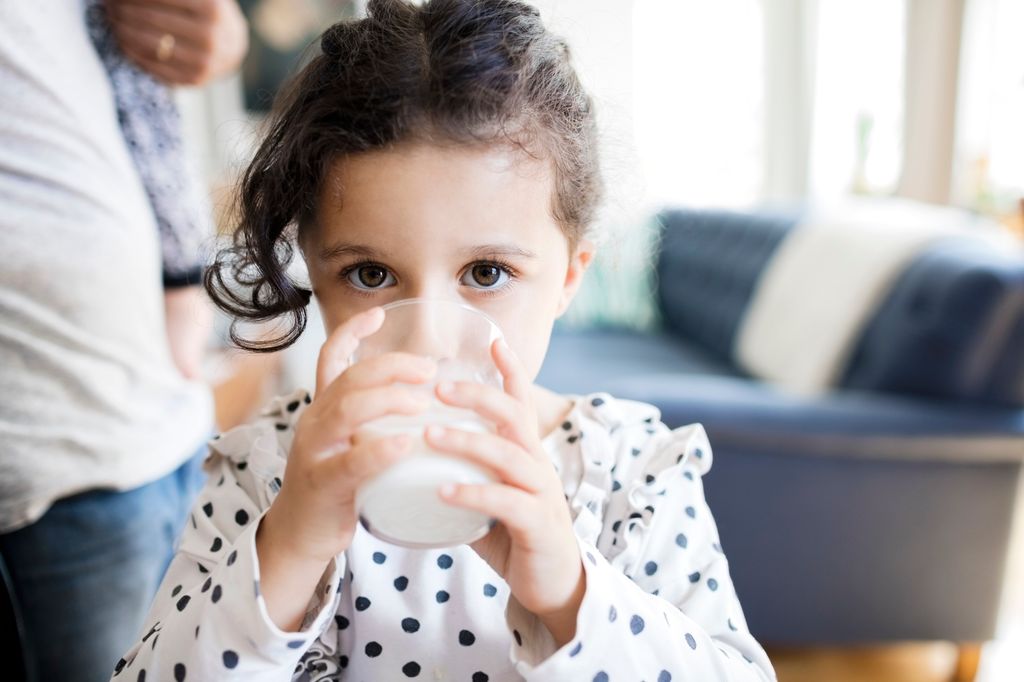 Niña bebiendo un vaso de leche