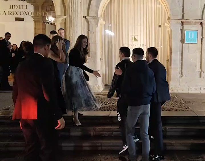 Plano medio de la Princesa Leonor e infanta Sofía haciéndose una foto con un grupo de fans en a la salida del Hotel Reconquista