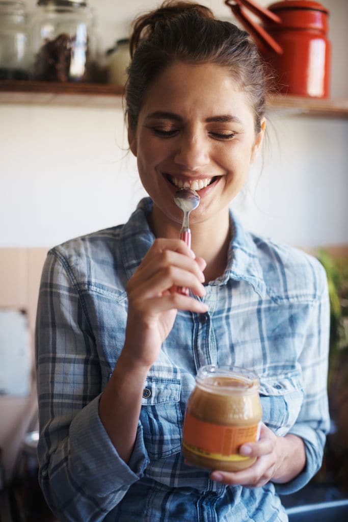 Una mujer tomando crema de cacahuete