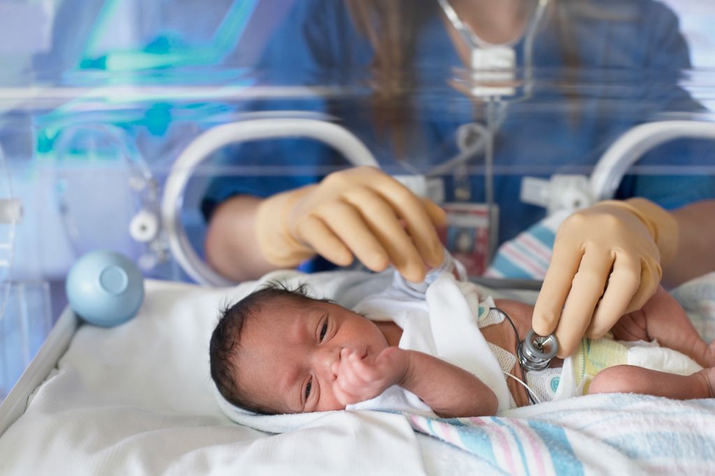 bebé en una incubadora en la UCI neonatal