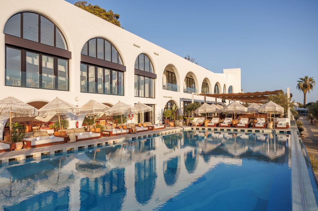 Eva Estepona cuenta con distintas áreas para comer y una piscina infinita rodeada de olivos y piedra natural, con tumbonas y camas balinesas.