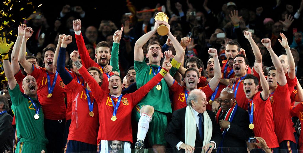 TOPSHOT - Spain's goalkeeper Iker Casillas (C) raises the trophy handed to him by FIFA President Sepp Blatter (4thR) and South Africa's President Jacob Zuma (3rdR) as Spain's national football team players celebrate winning the 2010 World Cup football final Netherlands vs. Spain on July 11, 2010 at Soccer City stadium in Soweto, suburban Johannesburg. NO PUSH TO MOBILE / MOBILE USE SOLELY WITHIN EDITORIAL ARTICLE - AFP PHOTO / GABRIEL BOUYS (Photo by GABRIEL BOUYS / AFP) (Photo by GABRIEL BOUYS/AFP via Getty Images)