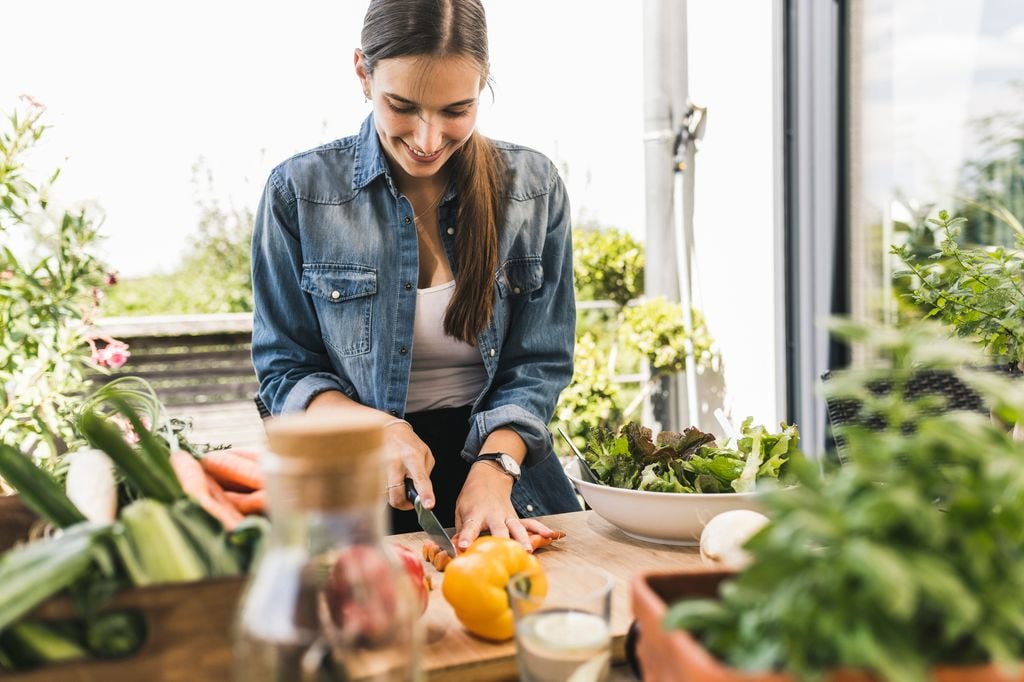mujer cortando verduras en la cocina