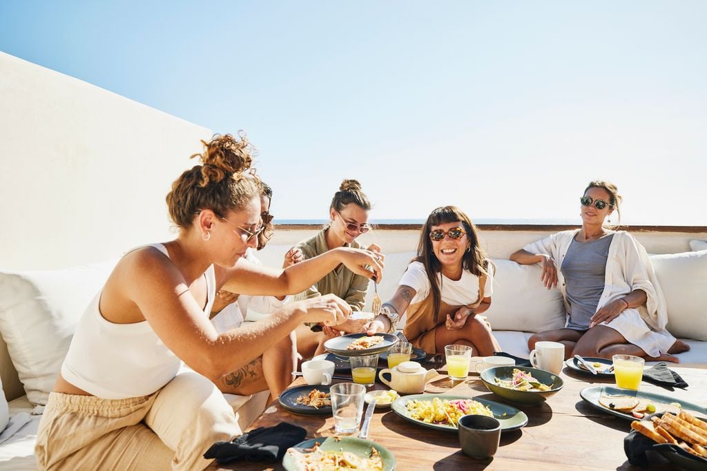 Mujeres jóvenes comiendo al aire libre en verano