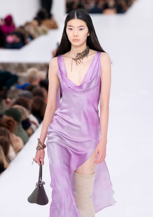 Una modelo desfila con un vestido morado de Acne Studios