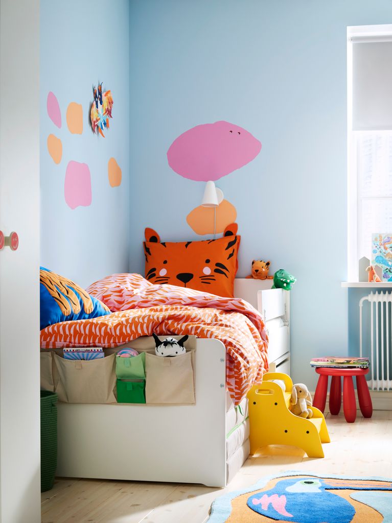 Dormitorio infantil en el que reina el azul claro, pero que aplica otros toques de color en amarillos, rosas, naranjas...
