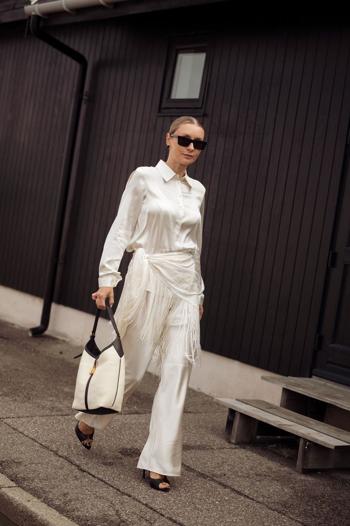 Justyna Czerniak, con un conjunto blanco y accesorios negros, en la Semana de la Moda de Copenhague (agosto de 2026).