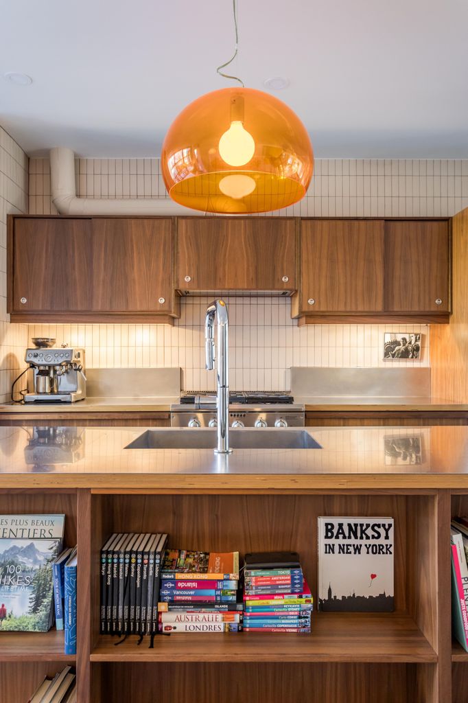 Cocina con muebles de madera y lámpara de cristal naranja