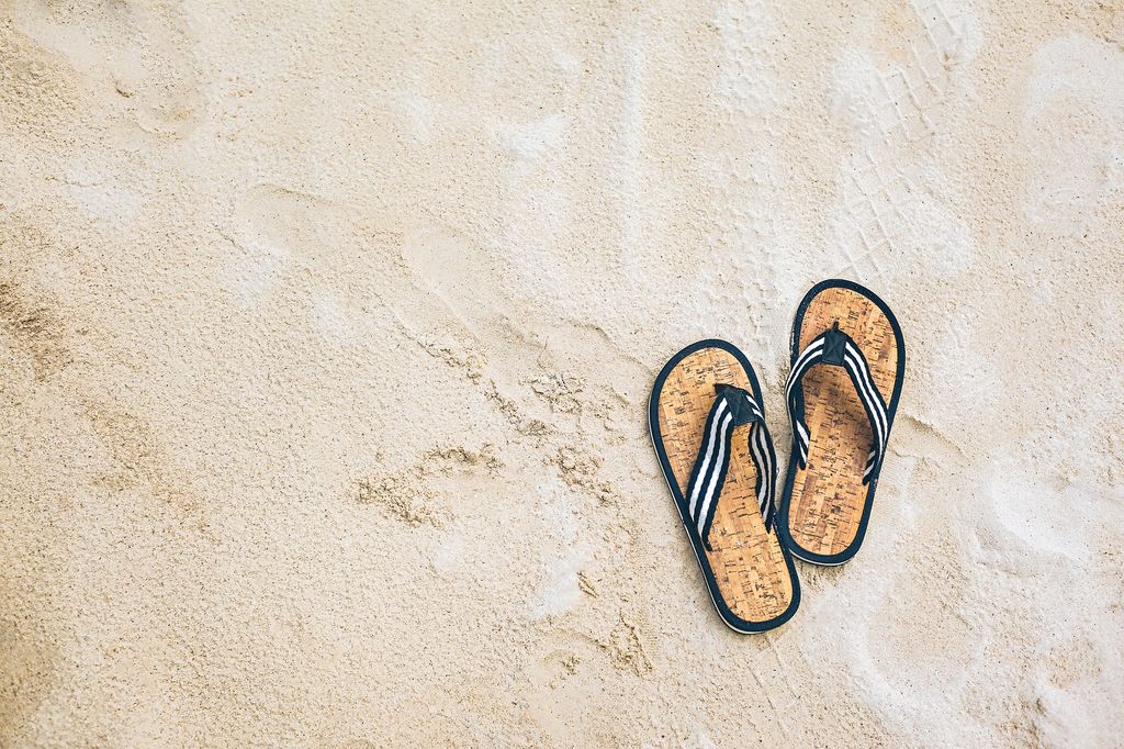 Chanclas en la arena de una playa de las Maldivas