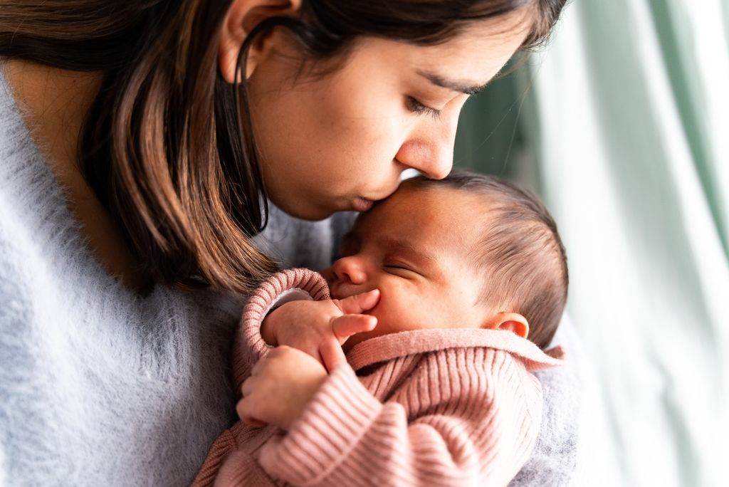 Madre besando a su bebé recién nacido