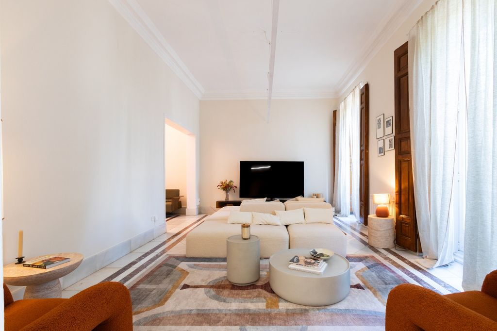 Salón con sofá blanco y butacas de color terracota