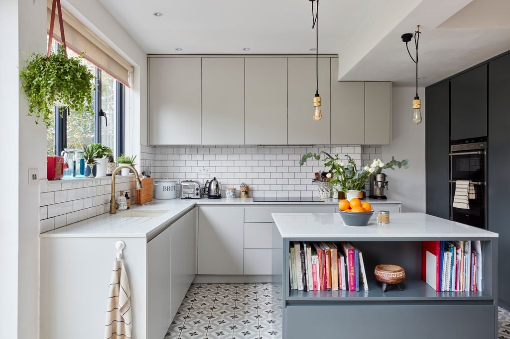 Cocina blanca con isla en gris y suelo hidráulico