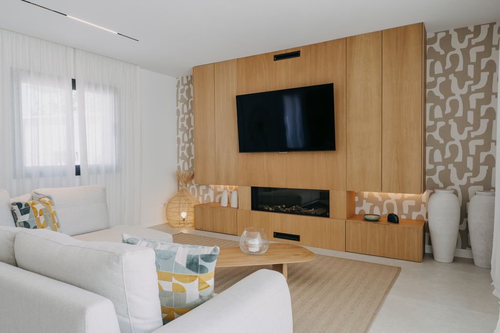 Salón con mueble a medida que integra chimenea y televisor