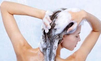 Mujer joven se lava el cabello