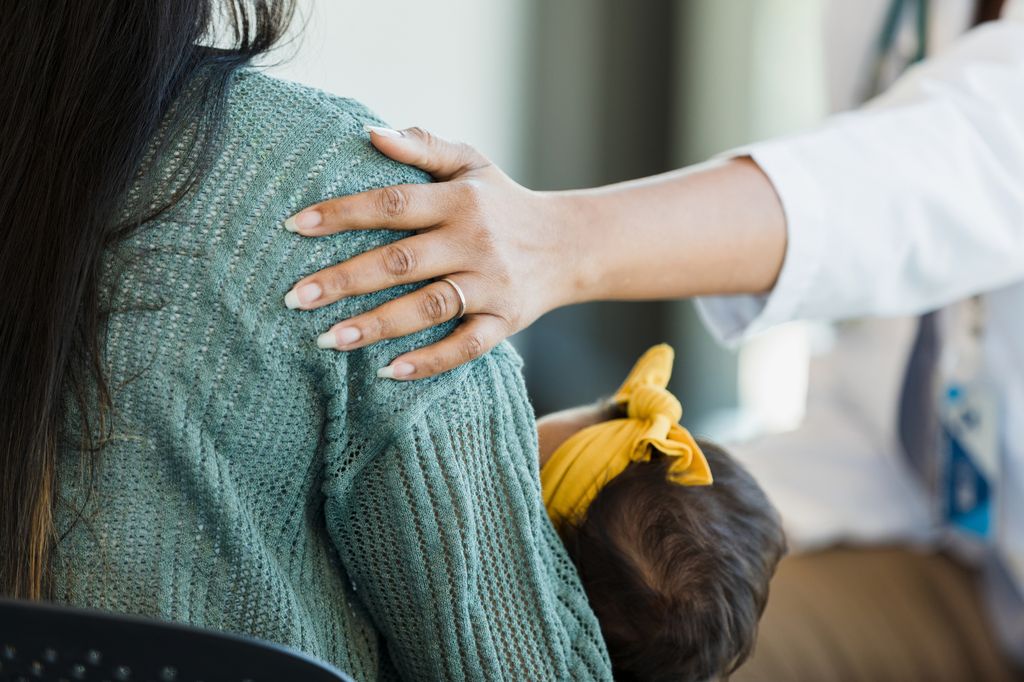Ayuda y comprensión en el posparto: mano que acaricia a madre