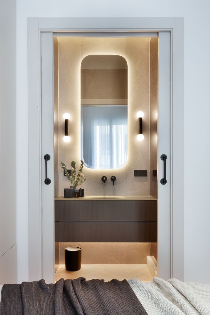 Baño con espejo y apliques de pared