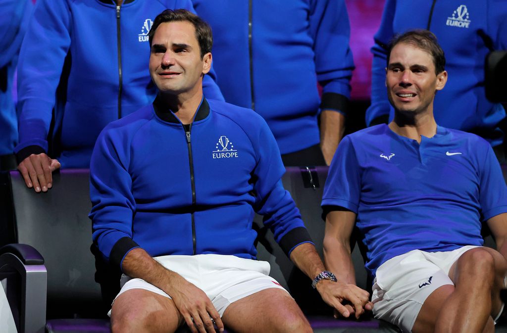 Plano medio de Rafa Nadal y Roger Federer sentados emocionados por la retirada de Federer