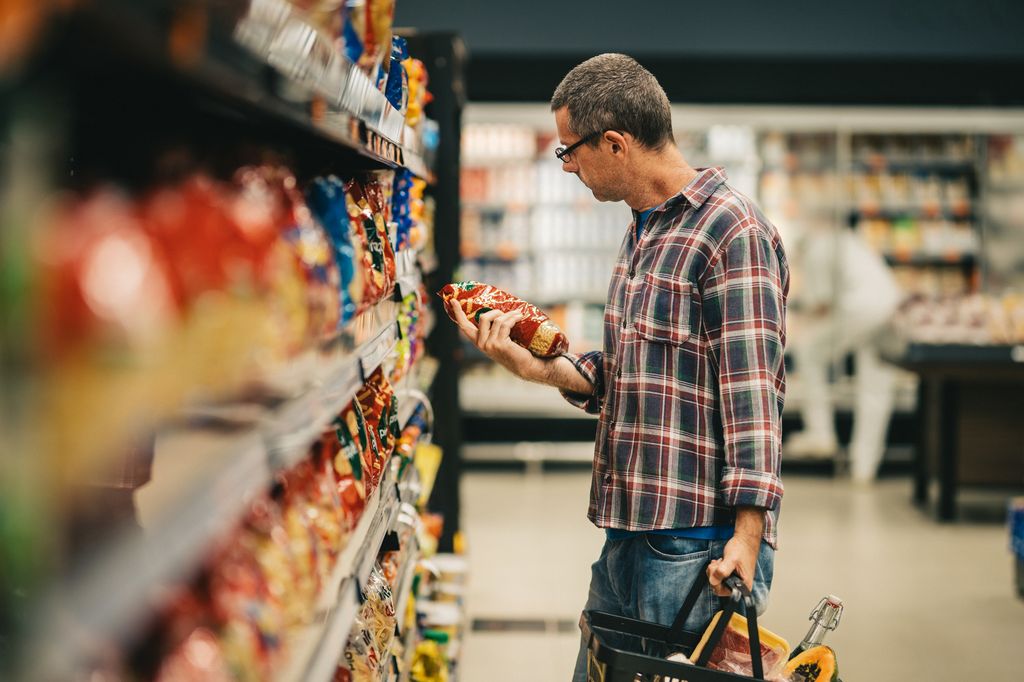 Un hombre revisando un producto en el supermercado