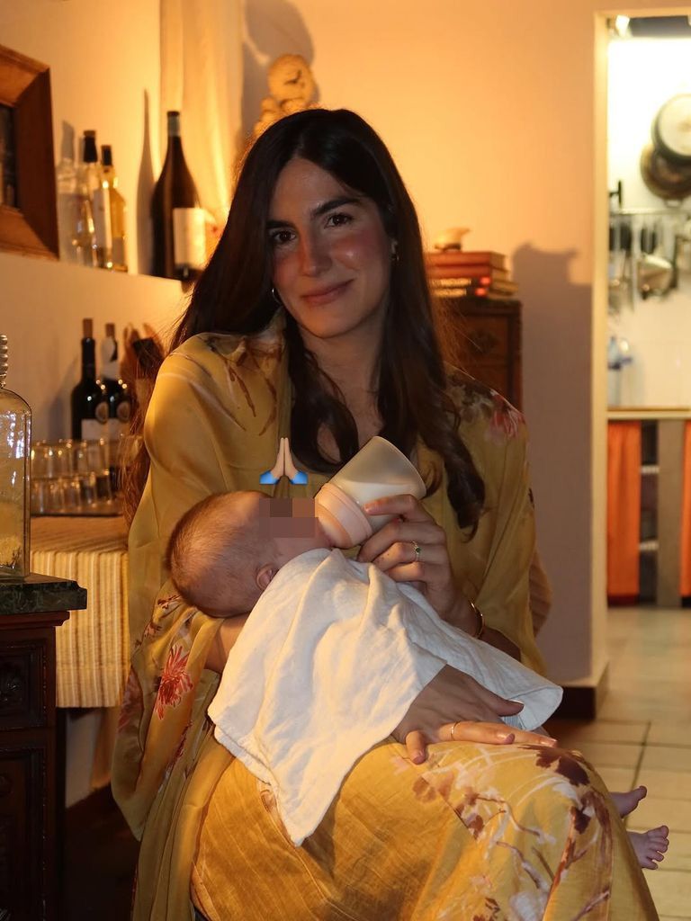 La orgullosa mamá, dando el biberón a su niño