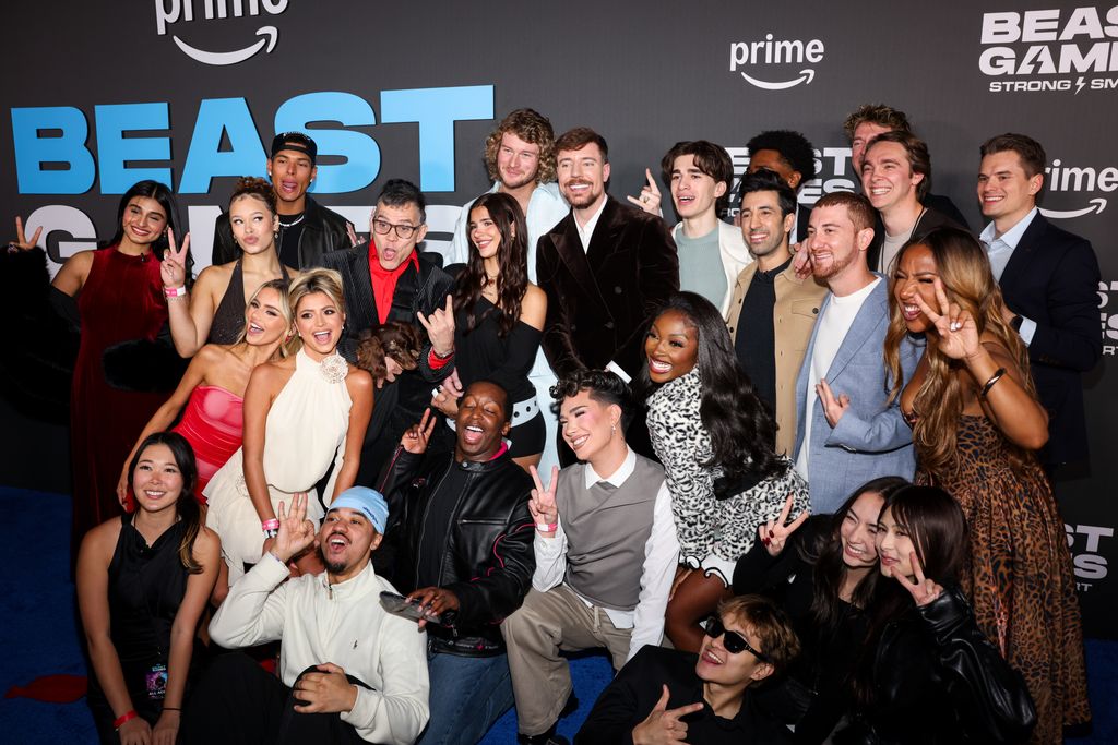 Grupo de celebridades en una premiere, incluyendo a James Charles, sonriendo y posando juntos.