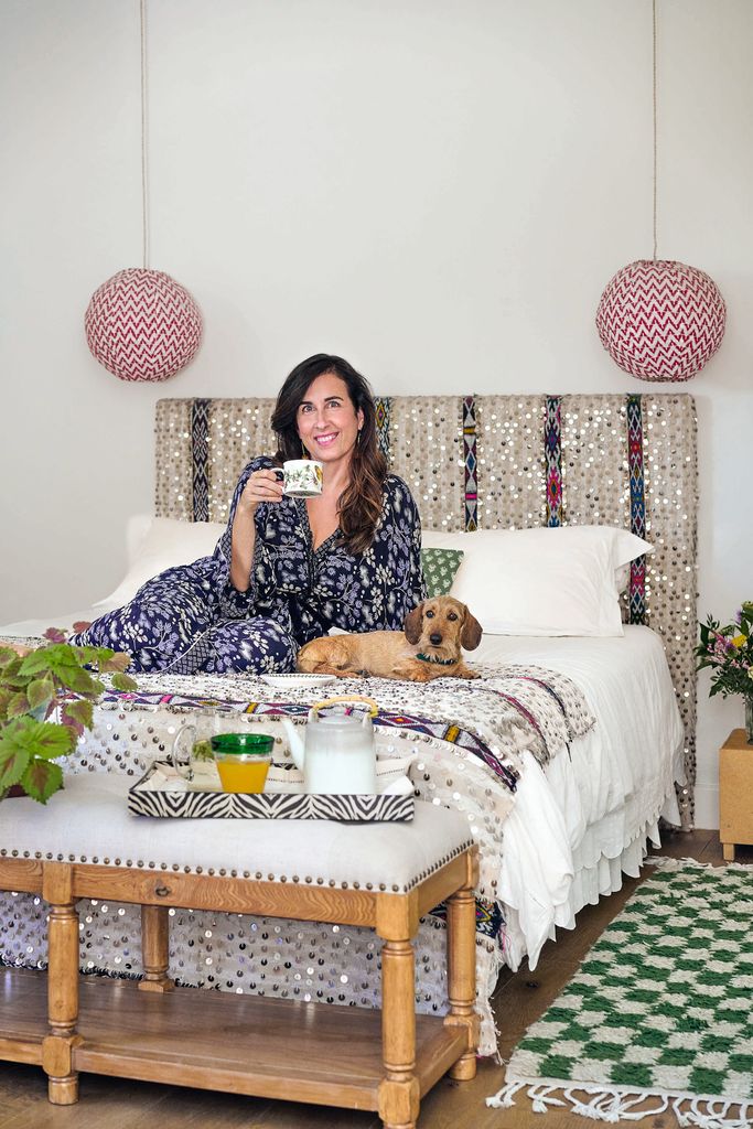 Macarena tomando café en su cama con su perro
