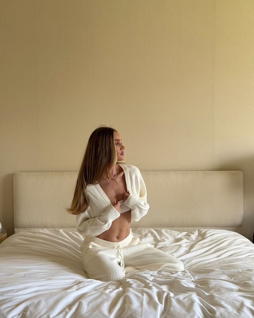 Rosie Huntington-Whiteley con conjunto blanco en la cama
