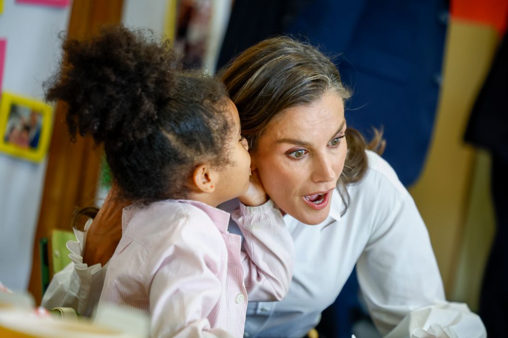 Gesto de asombro de la reina Letizia cuando una niña de infantil le cuenta un secreo al oido